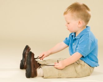 little boy thinking about tying his shoes
