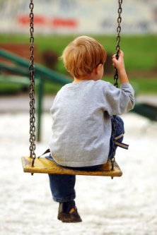 lonely preschooler swinging by himself