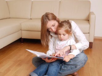 Single mom reading book to her daughter