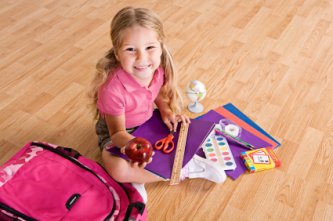 little girl with her school supplies getting ready for school