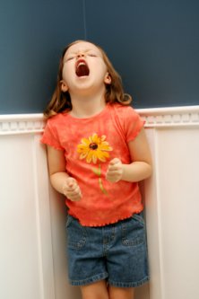 girl in corner throwing a temper tantrum