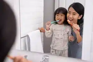 25 Parenting Hacks To Save Time, Hassle, and Energy 19 girl brushing teeth with mom