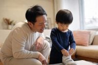 How to Build Confidence in a Child: 9 Gentle Habits That Help Them Thrive 1 A warm encouraging parent kneeling at eye level to show how to build confidence in a child, smiling as a young child tries a new task with a proud expression in soft natural light