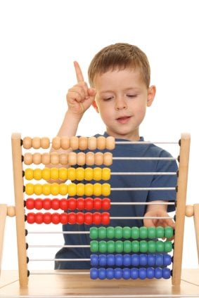 young boy learning to count on an abacus