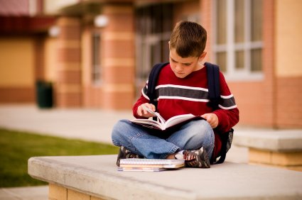 Tips For Starting A New School 8 young boy reading outside new school