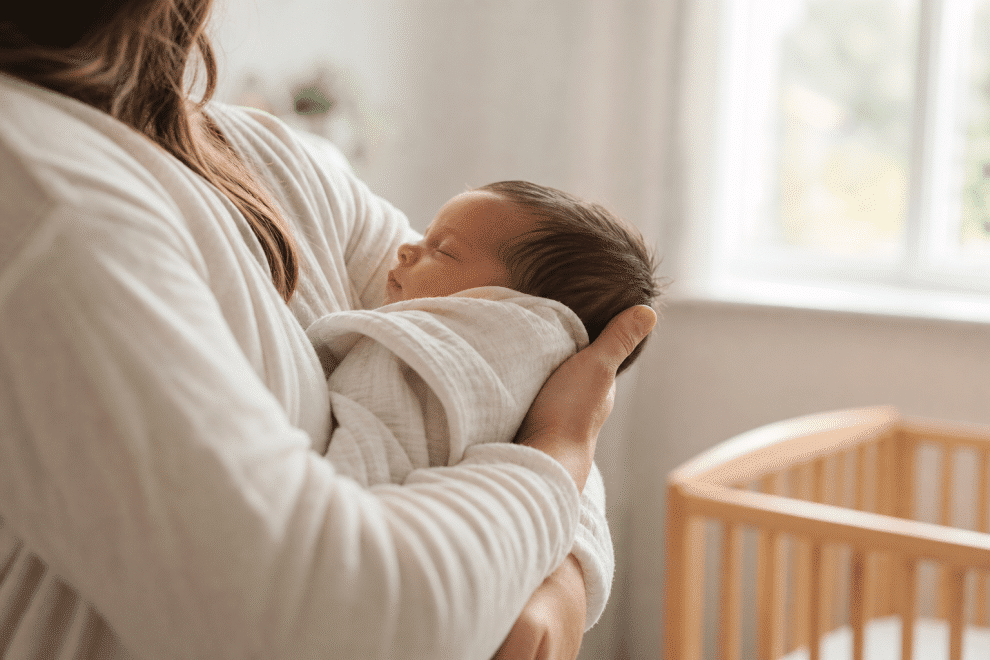 parenting a newborn - parent cradling newborn baby in soft nursery light