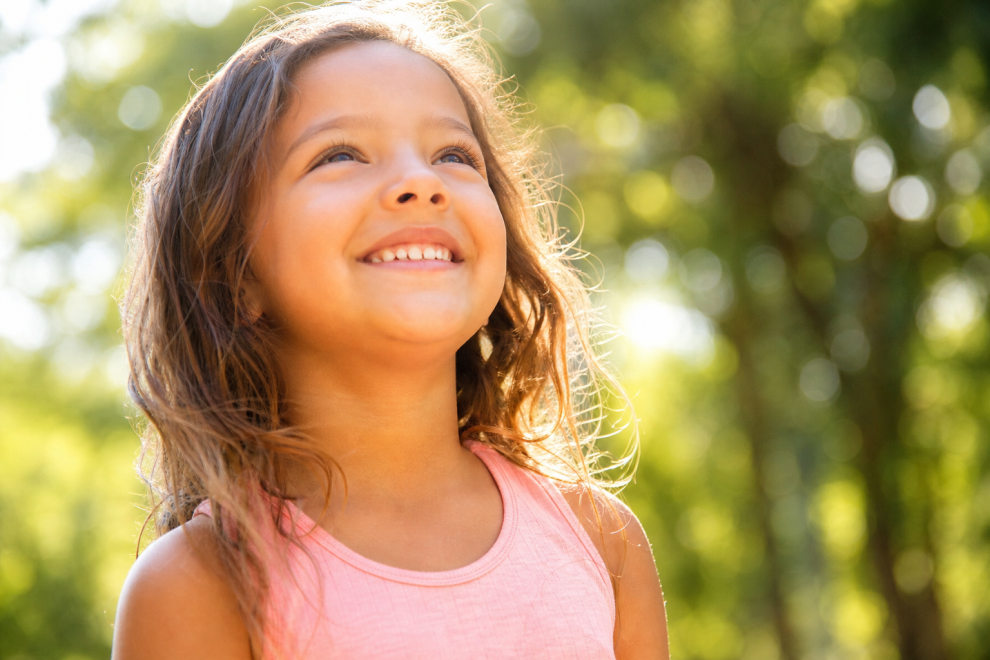 Parenting and Raising Optimistic Kids 15 Optimistic kids smiling brightly outdoors