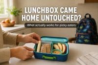parent packing a simple picky eater school lunch with familiar foods — cheese stick, crackers, apple slices