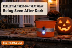 Reflective trick or treat safety gear on a bucket with a visible reflective strip and a clipped-on LED safety light sitting on a porch step at dusk beside a jack-o-lantern