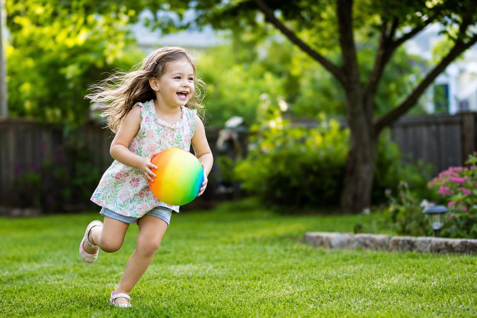 How Much Screen Time for Kids? A Calm, Practical Guide for Real Families 16 A young child happily playing outdoors in a backyard with a ball, bright sunny day, showing the kind of active play that balances screen time for kids