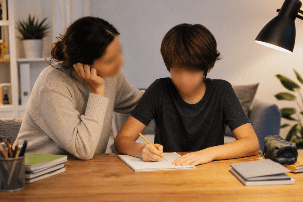 parenting a child with ADHD — parent helping child with homework at a desk