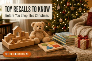 Wooden toys and a wrapped gift laid out beside a Christmas tree for a toy safety check